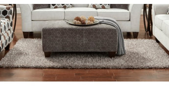 A sophisticated silver ottoman from Anna Collection featuring a chic design and comfortable seating.