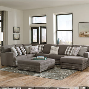 Gray nailhead customizable sectional in Springdale, Arkansas. The sectional includes a steel frame and all pillows, featuring durable, long-lasting fabric.